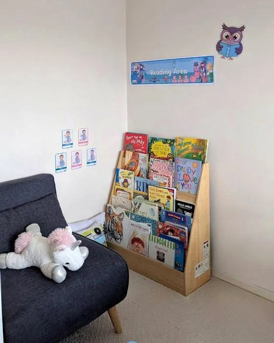 A cosy reading corner with a soft chair and a bookshelf of picture books